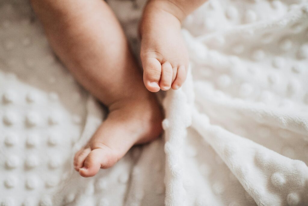 ”Eutanasian puolustajilla ei välttämättä ole henkilökohtaista kosketuspintaa kuolemaan” Close-up of baby feet on a textured white blanket, evoking warmth and innocence.